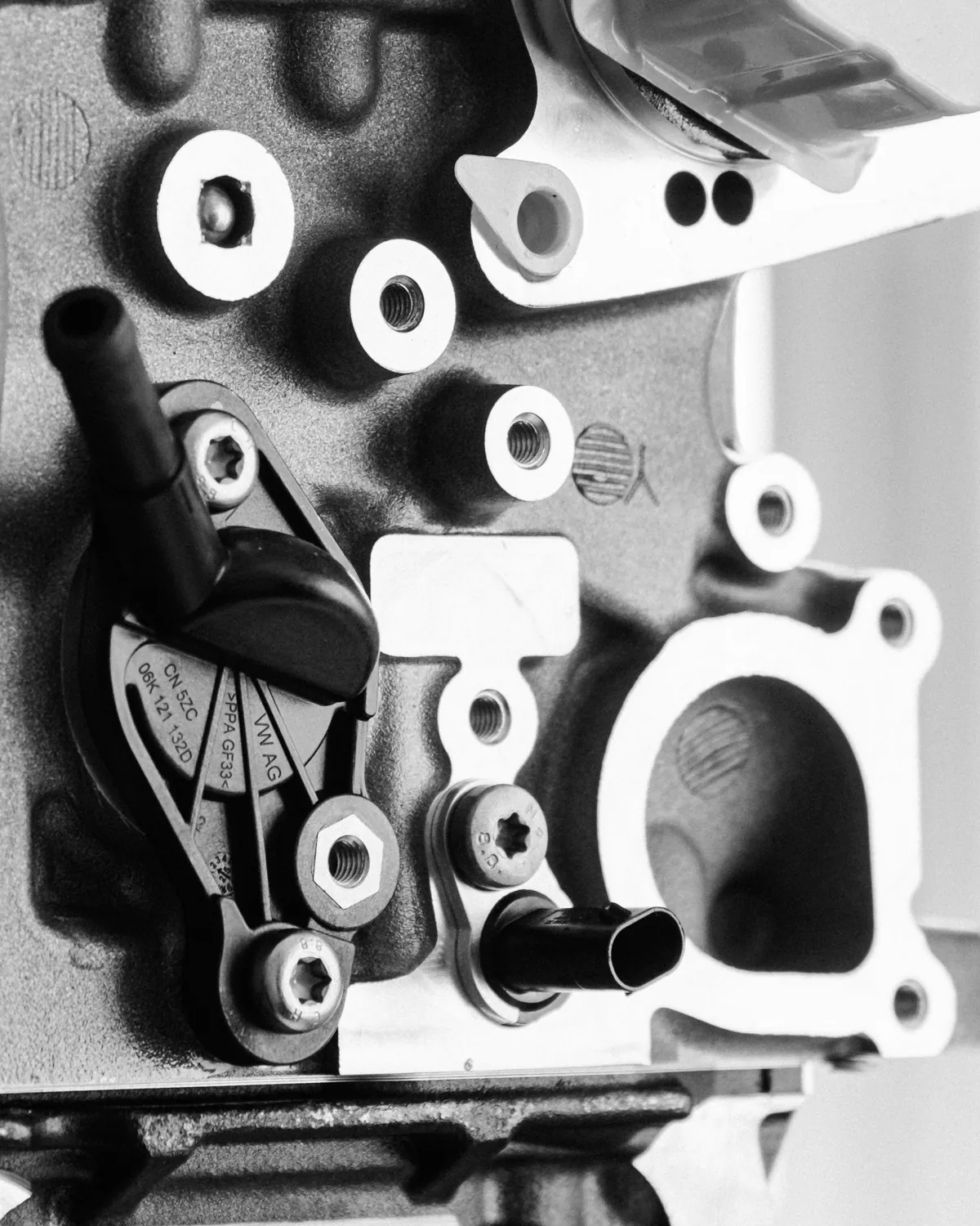 Machined face of a factory-new cylinder head showing valve seats and bolt holes