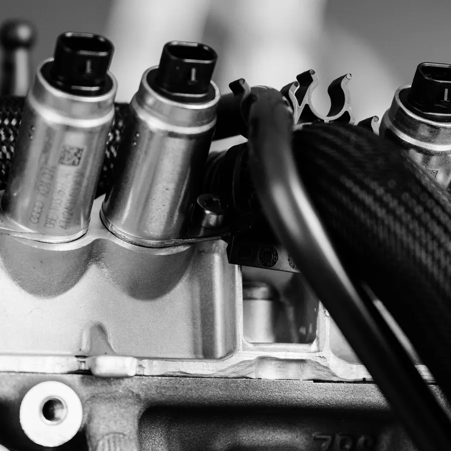 Close-up of black connectors on the metal components of a used engine